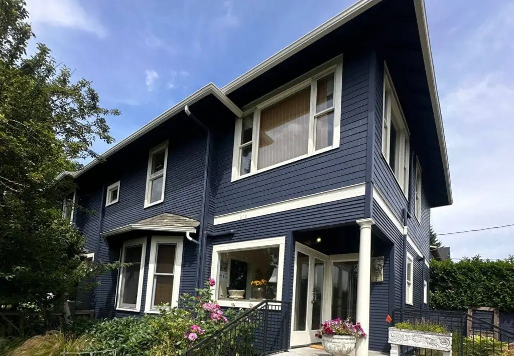 A beautifully updated two-storey home with a freshly painted blue exterior, completed by experienced Painters in Bellevue, WA.