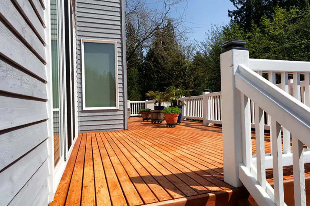 Freshly stained wood deck on a Seattle home exterior showing how long does deck staining last in Seattle weather conditions