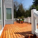 Freshly stained wood deck on a Seattle home exterior showing how long does deck staining last in Seattle weather conditions