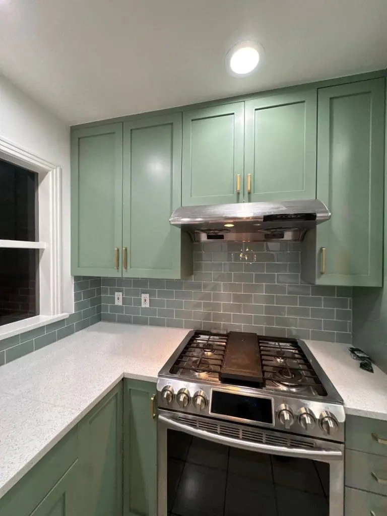 Professional kitchen cabinet painting featuring a seamless sage green finish by painters in Refined Painting LLC in Seattle, WA.