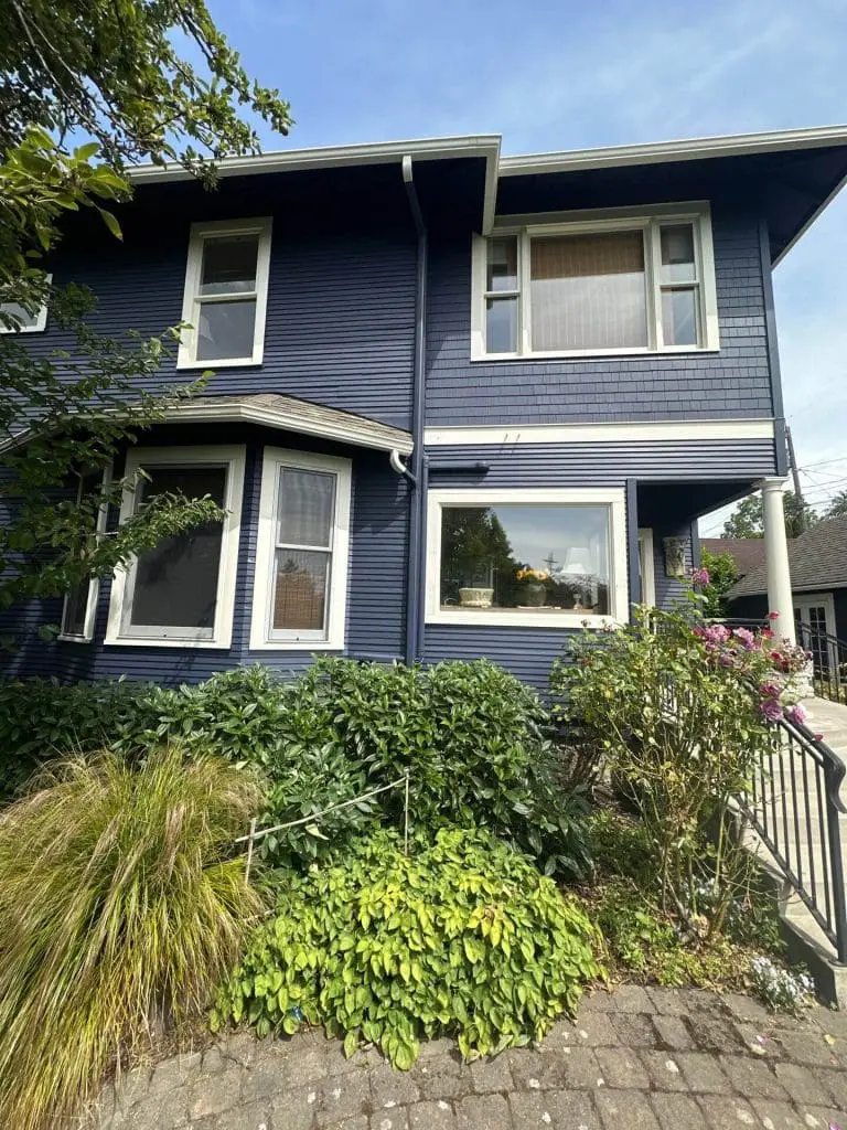 Elegant navy blue exterior lap and shingle siding meticulously finished by painters in Refined Painting LLC in Seattle, WA.