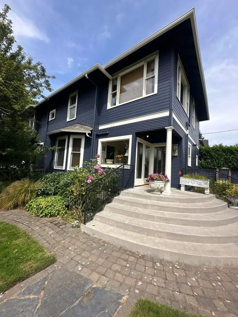 A Seattle home featuring professional exterior siding painted in deep navy blue with crisp white trim by Refined Painting LLC.