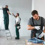 A commercial painting crew rolling and applying paint to interior walls, showing a professional commercial painting project in progress in a Seattle business.