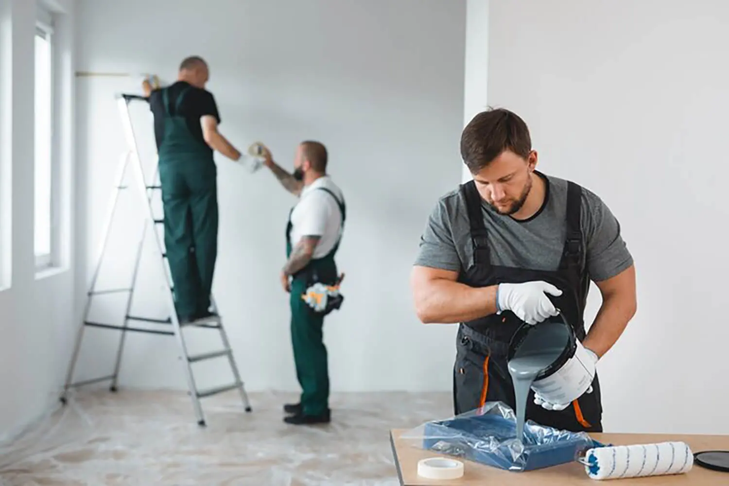 A commercial painting crew rolling and applying paint to interior walls, showing a professional commercial painting project in progress in a Seattle business.